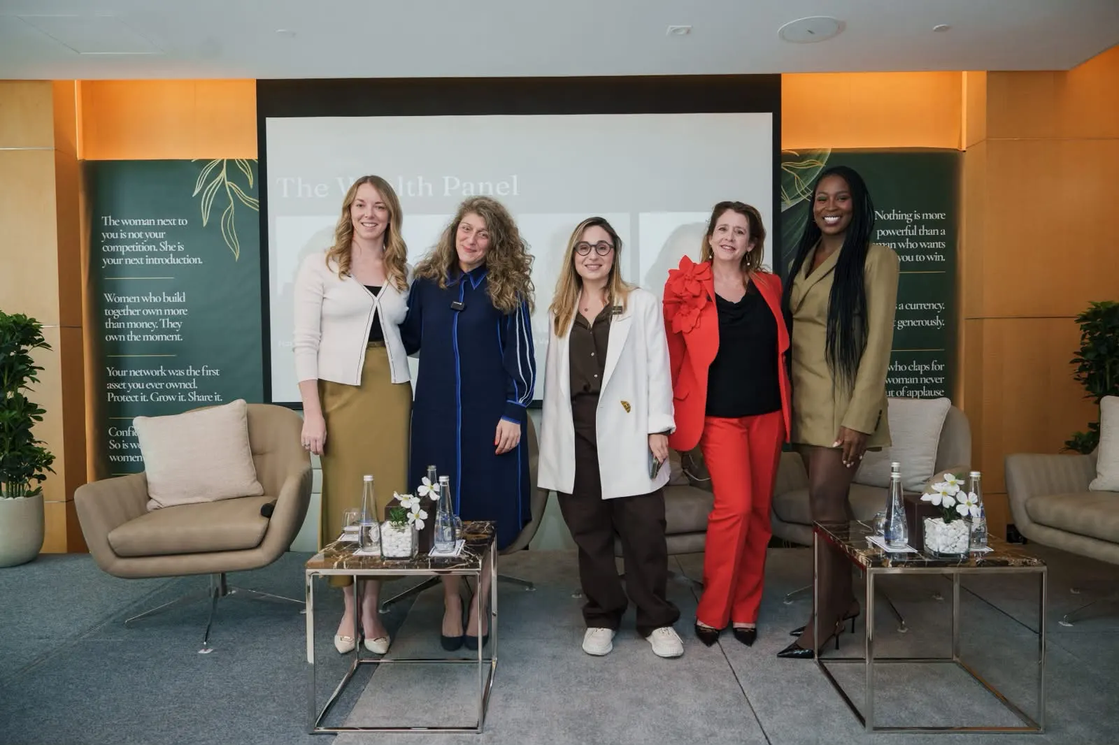 Six women standing together on the Wealth Room stage after the panel.